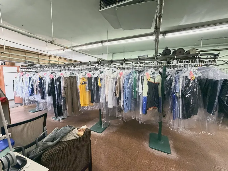 Rows of freshly cleaned garments in plastic on the shop's conveyor rack