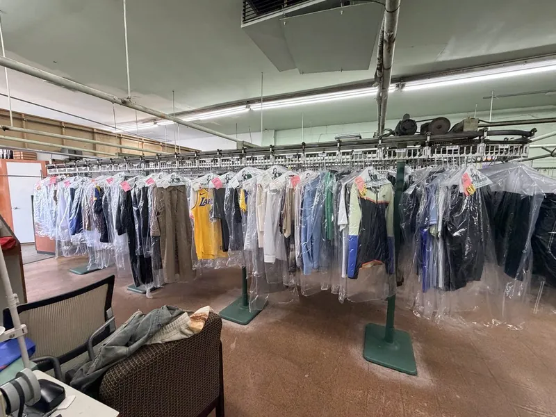 Rows of freshly cleaned garments in plastic on the shop's conveyor rack